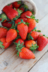 strawberries in small sack on wooden table background
