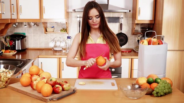 Woman hands peeled orange fruit with knife 4K