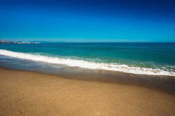 Fototapeta na wymiar Sea Ocean Waves Wash Over Golden Sand Background