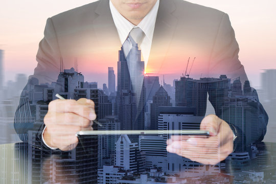 Double exposure of business man working with tablet, city, urban and sunset as communication and technology concept.