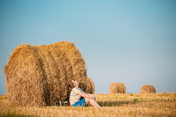 Naklejka na ściany i meble Beautiful Plus Size Young Woman In Shirt Sit Near Hay Bales In S