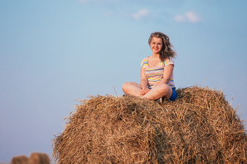 Naklejka na ściany i meble Beautiful Plus Size Young Woman In Shirt Sit Near Hay Bales In S