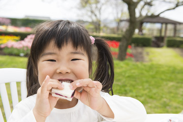 公園でサンドイッチを食べる女の子