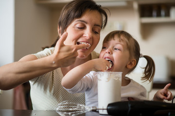 Licking of  whipping cream - mother with daughter