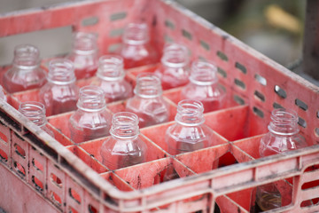 Empty plastic bottle in red crate with selective focus.