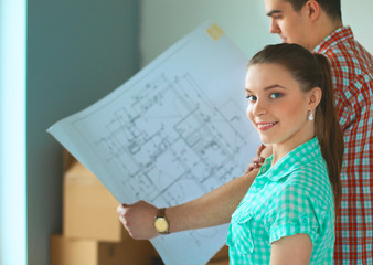 Portrait of young couple moving in new home with plane