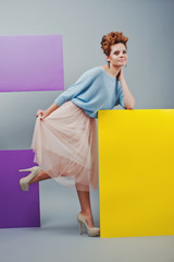 Full length studio portrait of young girl near art colored blank