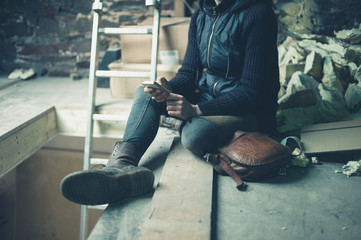 Young woman using cell phone in loft space