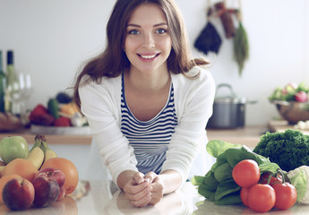 Young woman standing near desk in the kitchen