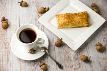 Cup of coffee, sweet buns and acorns