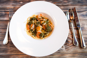 Italian paste with quail egg and shrimps on a dark wooden backgr