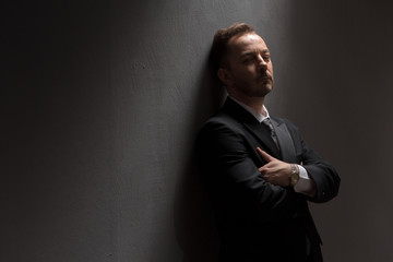 Fototapeta premium Portrait of young businessman posing for photographer with his arms crossed or folded over grey background in studio.