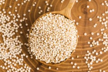 White quinoa seeds on a wooden background