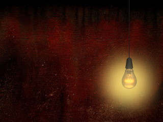 Close-up of one yellow turned on light bulb against dirty red concrete wall background