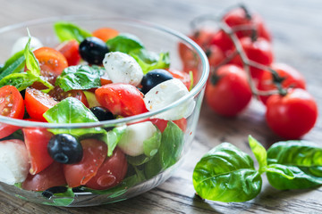 Obraz na płótnie Canvas Salad with tomatoes, olives, mozzarella and basil