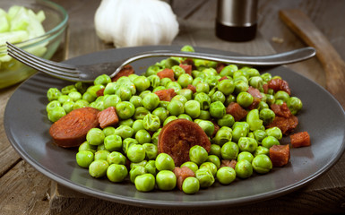 dish cooked with ham and chorizo peas in old wooden