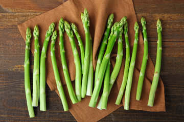 delicious asparagus on fabric on wooden brown background