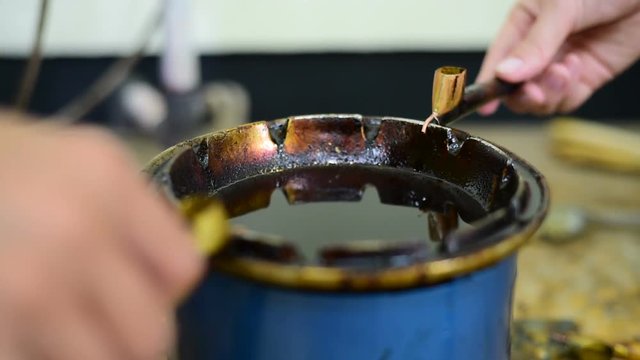
Filling canting with wax for making batik
