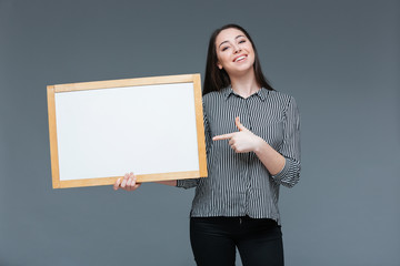 Fototapeta na wymiar Businesswoman pointing finger on blank board
