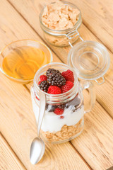 transparent jar with berries and yogurt cereals