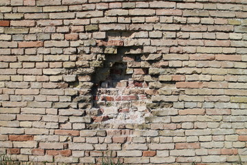Red brick wall with hole
