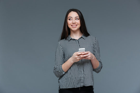 Smiling businesswoman holding smartphone