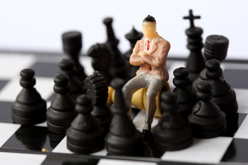 Businessman model on chess board.