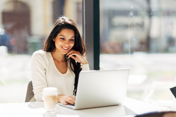 Fototapeta premium Brunette using laptop in cafe
