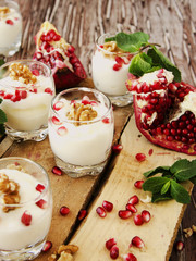 yogurt dessert with walnuts and pomegranate selective focus