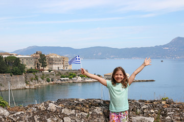 happy little girl with Greek flag on summer vacation Corfu town