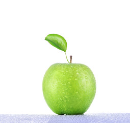 Green apple on wet surface with isolated background