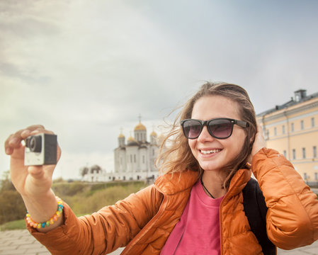 young woman traveler with a camera in hand. Against the backgrou
