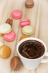 Cup of black coffee with french colorful macarons, sweet delight