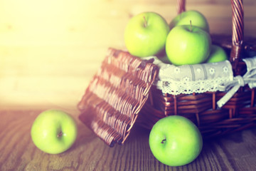 sunlight green apple in a basket wooden background
