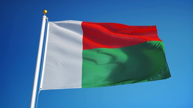 Madagascar flag waving in slow motion against clean blue sky, seamlessly looped, close up, isolated on alpha channel with black and white luminance matte, perfect for film, news, digital composition