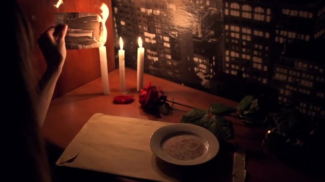 A woman burns the photo with the man