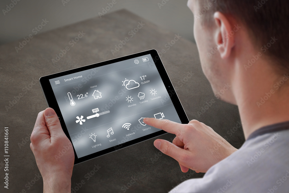 Poster man use application for smart home control on tablet. interior of living room in the background.