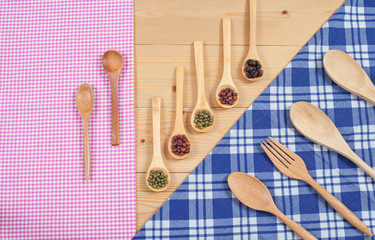 Tablecloth, wooden spoon, fork on wood textured background