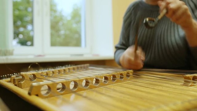Woman playing the dulcimer in the College of Music