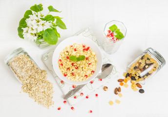 Healthy breakfast with porridge, nuts, yoghurt and pomegranate