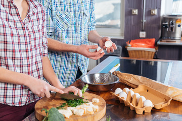 Young couple standing and cooking breakfast together