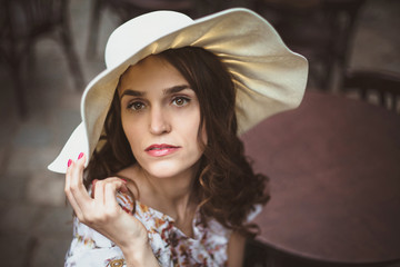 Lady in white hat looking thoughtful and sensitive