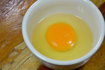 raw egg in cup on table