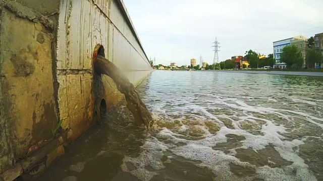 Sewage Pipe Discharging Into The River. The drain carries sewage