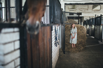 funny lady lying on hay in barn and posing at the camera