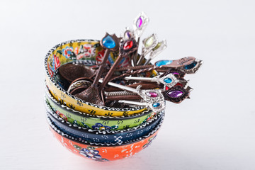 Traditional Turkish hand made ceramics,spoons with colored stones on white background.selective focus.