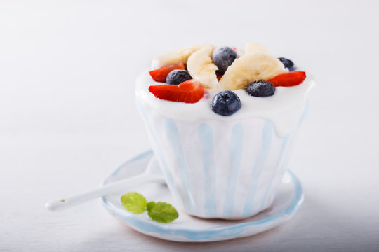 Yogurt,homemade in a ceramic bowl with berries and mint on a white background.selective focus.