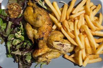 Grilled chicken legs with chips and vegetables