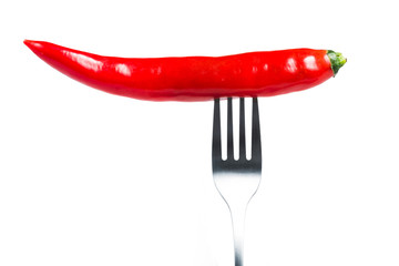 Fototapeta na wymiar Chili pepper i on fork on red background. Healthy eating concept.
