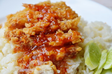 fried chicken on steamed rice dressing sweet chili sauce on dish